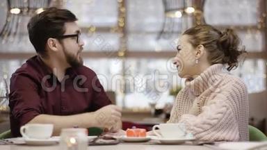 一个成年人坐在餐馆里给他的妻子送他从服务员那里得到的花，她吻了他
