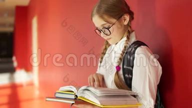 准备考试的女学生。 戴眼镜的女孩翻阅课本
