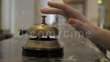 一个年轻女孩在酒店接待处使用服务钟的手