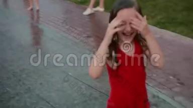 湿漉漉<strong>的</strong>小女孩跑过喷水喷泉，笑了起来。 孩子们在<strong>炎热的夏天</strong>玩得很开心。