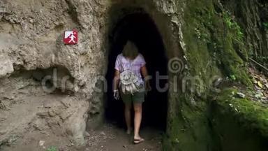 成年女游客独自走在有柱子的洞穴里。 慢动作