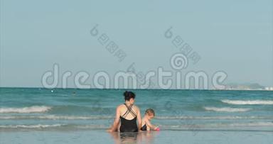 快乐和无忧无虑的母子在海边玩耍，晒日光浴，<strong>游泳</strong>。 <strong>儿童</strong>和成人在热带海域玩耍