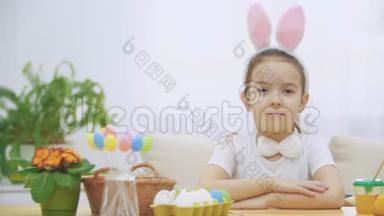 可爱可爱的小女孩在真诚地微笑。小女孩头上戴着小兔子的耳朵，正跳过来。复活节概念