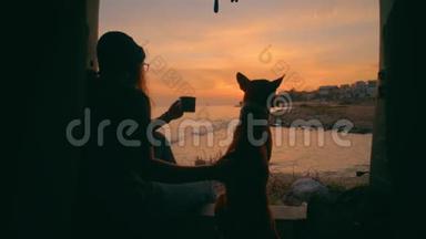 年轻女子和狗一起喝茶或咖啡