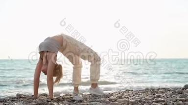 一位<strong>身材矮小</strong>、运动力强的海边女子仰着腰，背起身来，双手放在地板上，锻炼身体以保持身体健康