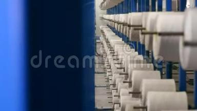 卷筒上的螺纹正在展开以制造织物。 纺织厂设备。
