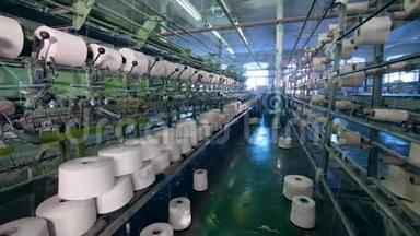 白色线的服装厂，机械地形成织物。 纺织厂设备。