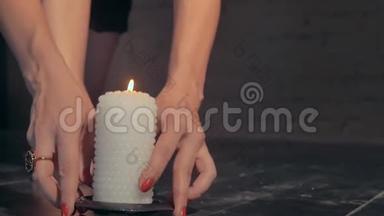 女孩把燃烧的蜡烛放在地板上。 光着脚