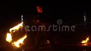 男演员在街上的消防表演中旋转一把燃烧的椅子