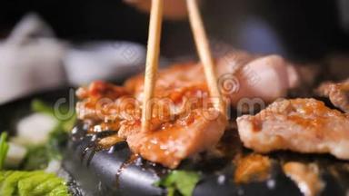人们用筷子做饭、捡猪肉、翻猪肉，在火锅上用深色和谷物的方法迎接韩国<strong>烧烤</strong>