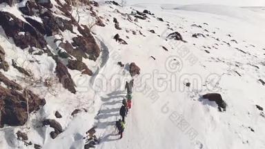 七位旅行者排成一队，到达一座覆盖着雪的山顶，这有助于他们的装备和背包