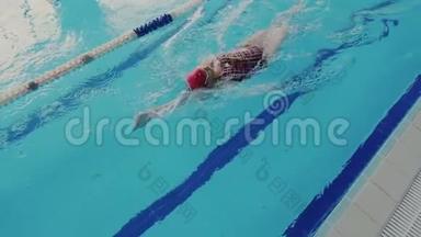 太慢了。 熟练的女游泳运动员在游泳池游泳和表演仰泳时的俯视图