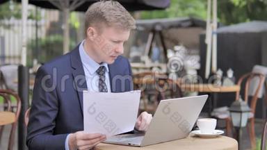 <strong>商务</strong>人士在户外咖啡厅阅读文件