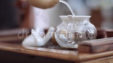 特写镜头展示茶道，茶被倒进一个特殊的玻璃容器里
