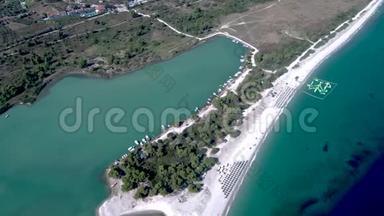 鸟瞰雄伟的海滩与绿松石水域和树木在格拉罗卡沃斯，哈基迪基希腊，侧面移动无人机