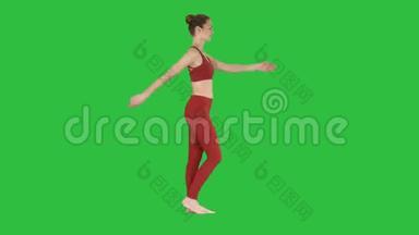 金发瑜伽教练在绿色屏幕上走来走去，挥舞着她的手，Chroma键。