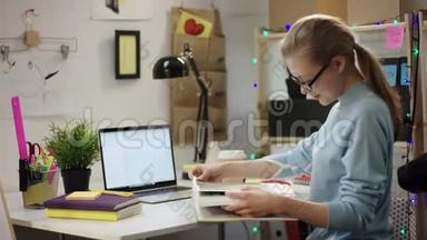 年轻女子用笔记本电脑一桌一桌地看书
