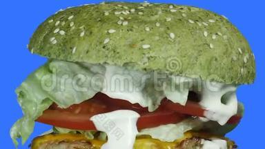 一架照相机`<strong>一个</strong>汉堡的自上而下的爆裂<strong>声</strong>中，有<strong>一个</strong>绿色的面包和<strong>一个</strong>绿色的西红柿和洋葱的馅饼在<strong>一个</strong>