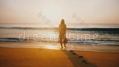 令人难以置信的后景拍摄了年轻快乐的女人在金色的海滩上观看惊人的日落，大浪来袭。