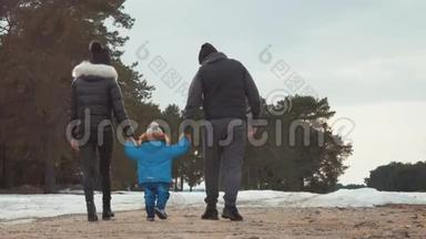 幸福的家庭在冬天的森林里散步。 亲子关系、季节和人的概念。