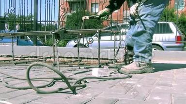 夏季晴天在一个施工现场，工人进行焊接金属产品的焊接工作。 特写
