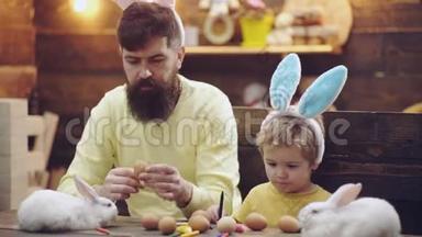 父子画复活节彩蛋.. 复活节假期。 为复活节做准备的幸福家庭。 复活节快乐。 复活节彩蛋。 复活节