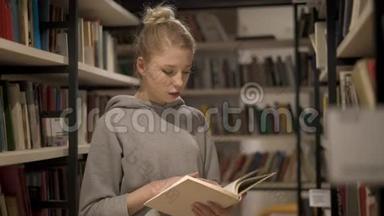 一个年轻的金发女孩在图书馆的<strong>书架</strong>间<strong>看书</strong>