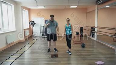 体育教练为胖子在健身房或健身<strong>中心</strong>进行<strong>个人</strong>训练。 胖子运动后累得满头大汗
