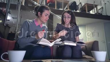 两个正在准<strong>备考</strong>试的小女孩坐在桌旁讨论书本