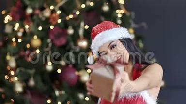 戴着圣诞老人帽子和西装、微笑着送礼物的亚洲幸福女人的肖像