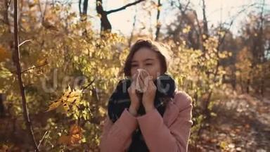 秋日，年轻的病妇站在公园里打喷嚏，用手帕