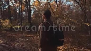 秋日，一个英俊的男人独自穿过森林，摄像机在<strong>四处</strong>移动