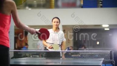 打乒乓球。 年轻女子和另一个女人打乒乓球