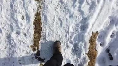 希克尔的观点。 一个人走在草地和雪地之间的山路上的POV特写