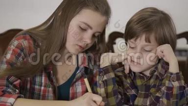 姐姐帮<strong>弟弟</strong>做家务。 两个可爱的孩子一起做作业的肖像。