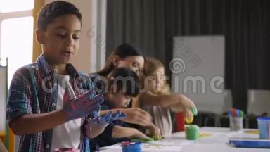 可爱的多样化的孩子在课上用手画画