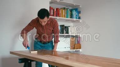 穿着格子衬衫的人正在整理<strong>木制</strong>橡木桌子，家里有一个<strong>滚</strong>筒