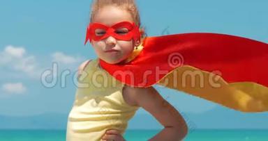 在超级<strong>英雄</strong>服装，穿着红色斗篷和<strong>英雄</strong>面具的特写肖像美丽的小女孩。 土地