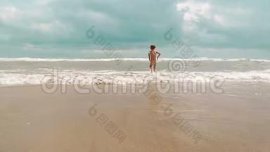 <strong>小女孩</strong>沿着沙质的海边<strong>奔跑</strong>，享受和享受海浪来到海滩。 愉快的假期