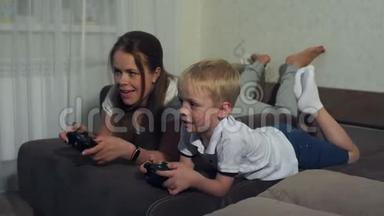 母亲和儿子<strong>玩电脑</strong>游戏，<strong>玩</strong>操纵杆躺在沙发上。