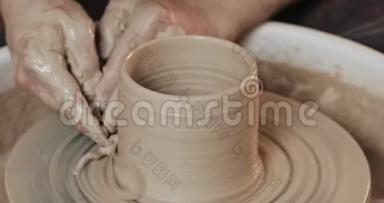 人的手创造罐子或花瓶的白色粘土。 扭曲锅`的车轮。 <strong>手工</strong>制作，<strong>手工</strong>制作