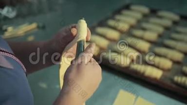 糖果女手正在转动不锈钢管，制作羊角面包。