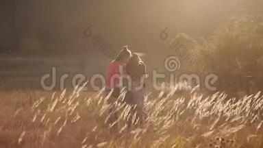 小幸福的女孩跑到她心爱的母亲身边。 妈妈在草原上，在草地上拥抱和亲吻女儿