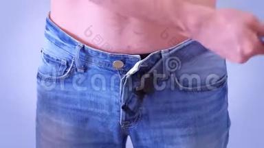 男人扣紧牛仔裤，穿上腰带，腰部和手部特写。