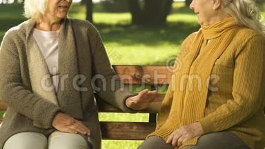 坐在长凳上的老女人，<strong>谈论</strong>最新消息，<strong>谈论</strong>邻居