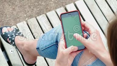 美丽的女孩手里<strong>拿</strong>着黑色的智能手机，手里<strong>拿</strong>着绿色的屏幕，手里<strong>拿</strong>着手机智能手机。