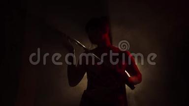 这个迷人的女孩站在一个光线昏暗、雾气弥漫的房间里，她的红色轮廓完美地传达了她的动作，