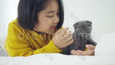 可爱的亚洲女孩和可爱的小猫<strong>玩耍</strong>，漂亮的女孩紧紧地抱着一只猫在<strong>室内</strong>