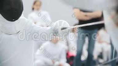 两个十几岁的女孩在体育馆举行击剑比赛
