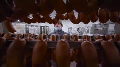 肉制品厂的一名员工端着一大堆香肠